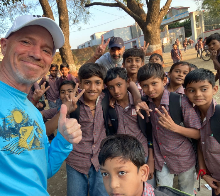Ron smiling with students in India